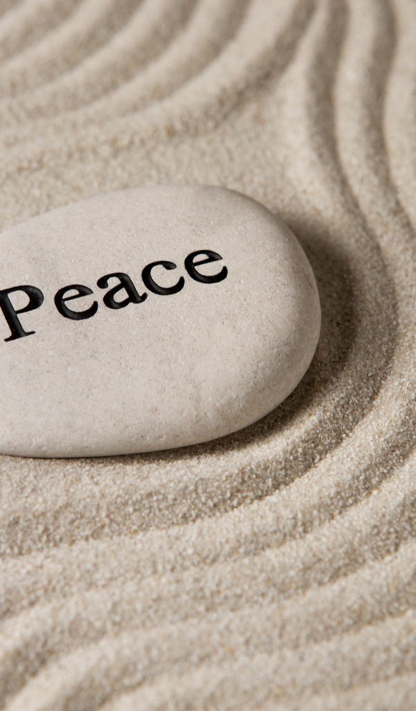 Белый камень с надписью на песке с волнами