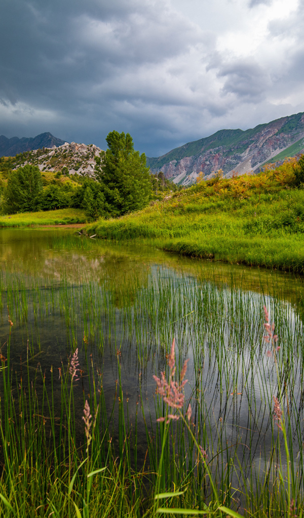 Грозовые облака над рекой в горах 