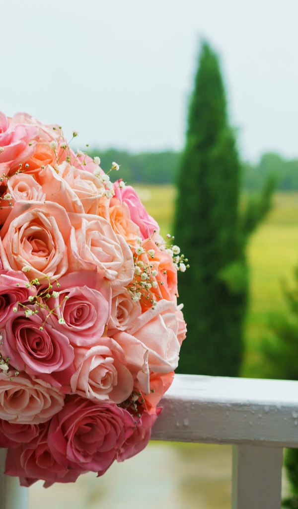 Красивый свадебный букет розовых роз на белых перилах