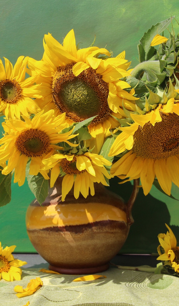 Букет подсолнухов в вазе на фоне стены