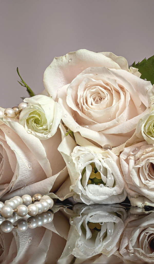 Букет белых роз с бусами на сером фоне