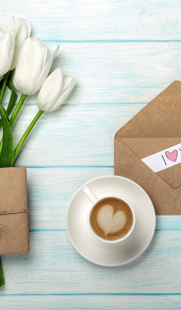 Букет белых тюльпанов на столе с подарком и чашкой кофе