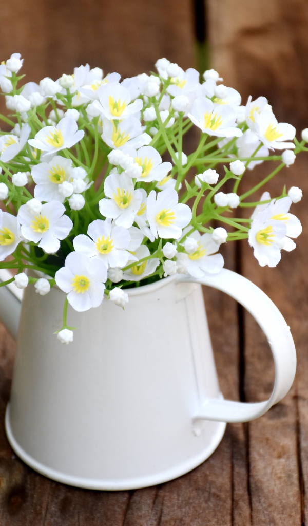 Маленькие белые цветы гипсофила в вазе на столе