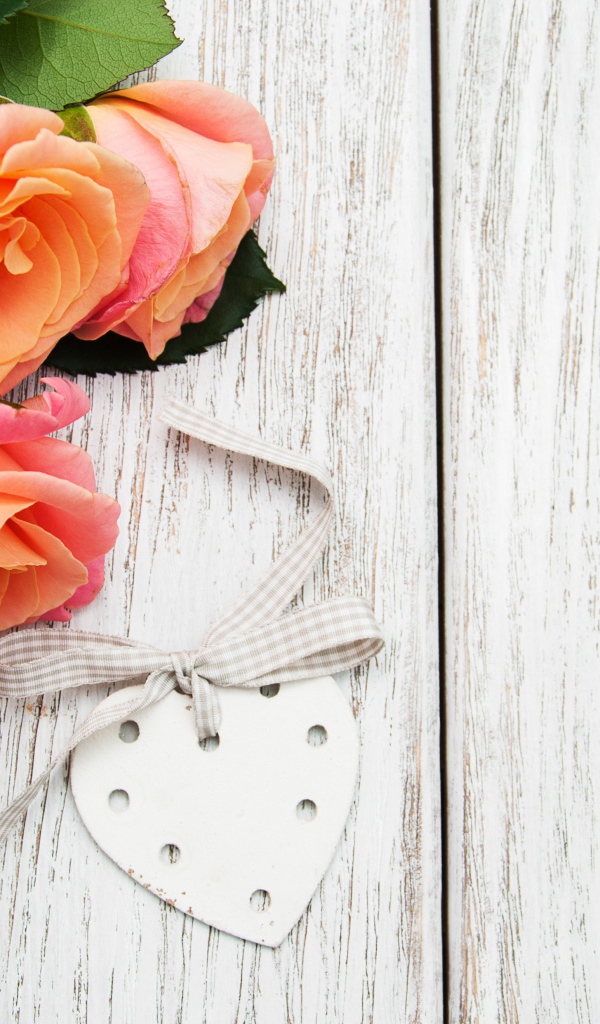 Три оранжевых цветка розы на сером столе