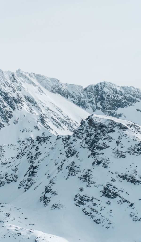 Заснеженная гора под серым небом 