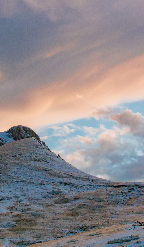 Красивые серые облака над заснеженной горой 