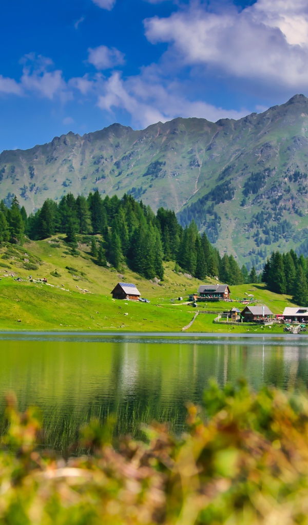 Красивый пейзаж на горы и озеро и зеленые луга