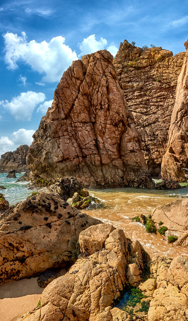 Большие каменные возвышенности в море под голубым небом 