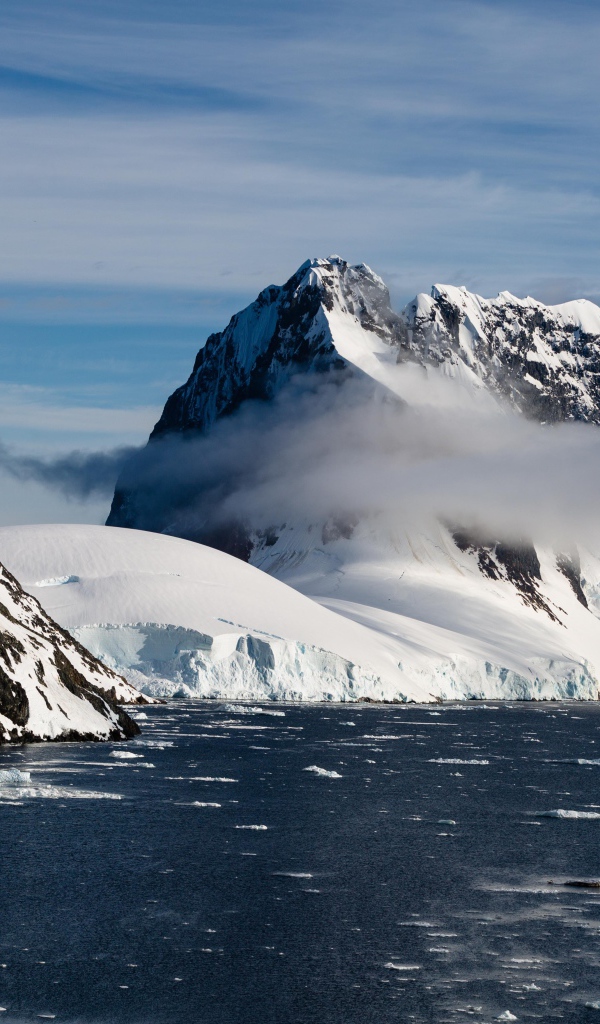 Заснеженные горы у покрытого льдом океана 