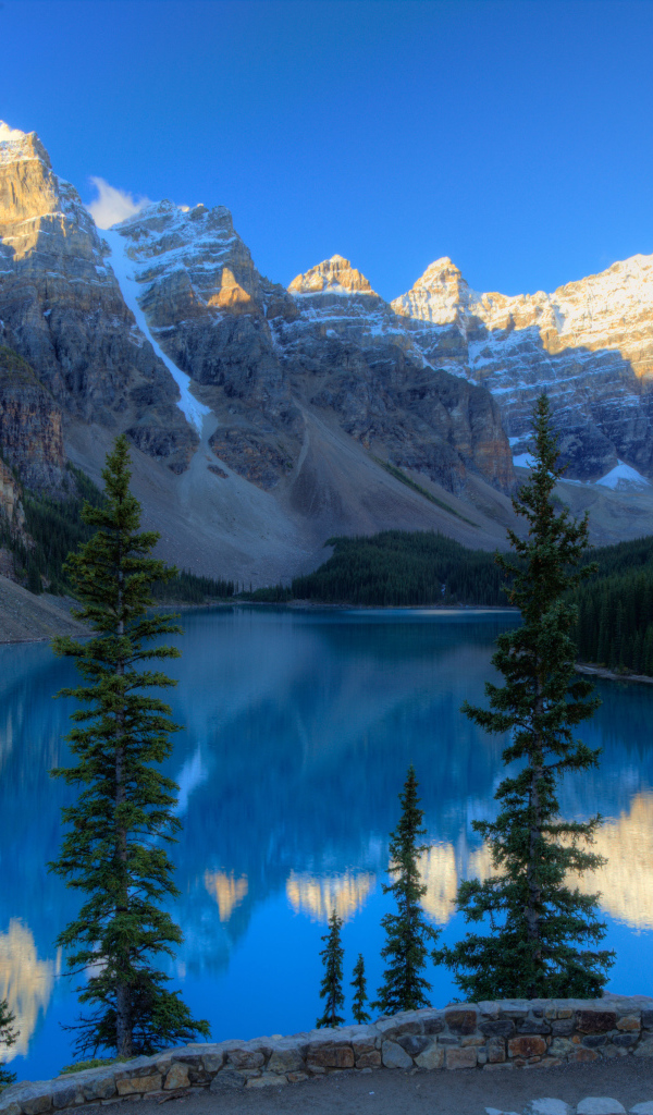 Каменные горы с заснеженными вершинами у озера 