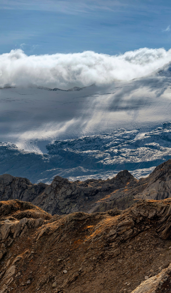 Густые белые облака над заснеженными Альпами