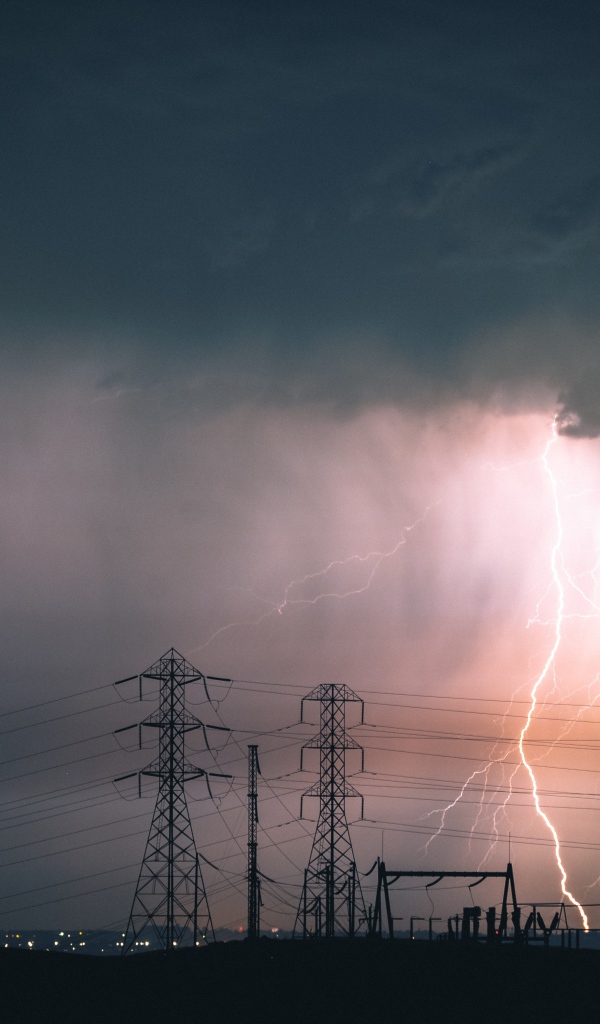 Яркая молния в небе над высоковольтной линией 