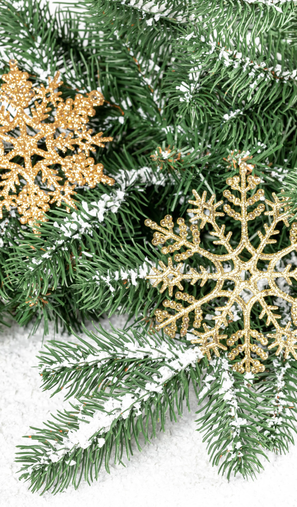 Золотистые снежинки и еловые ветки на снегу