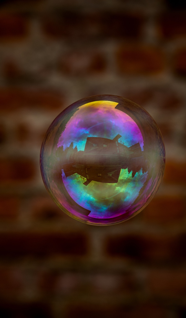 Мыльный пузырь в воздухе на фоне стены