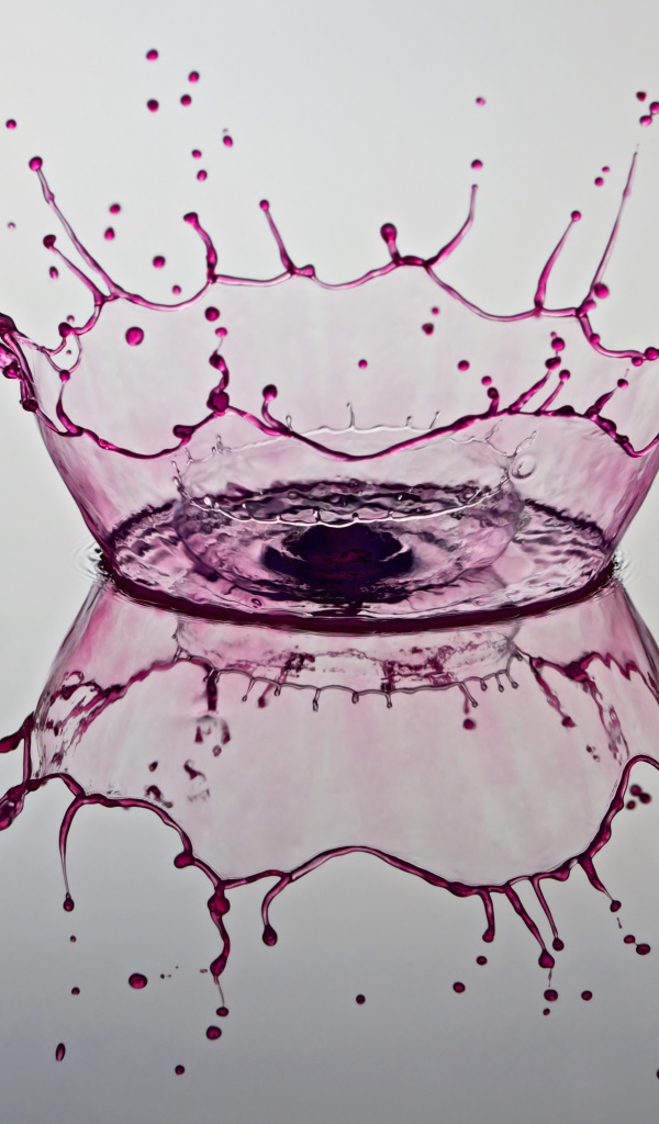 Брызги фиолетовой краски на сером фоне 