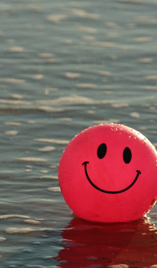 Красный мяч смайлик в воде 