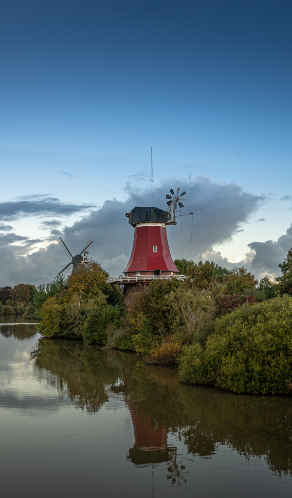 Мельница на берегу реки под красивым небом в сумерках
