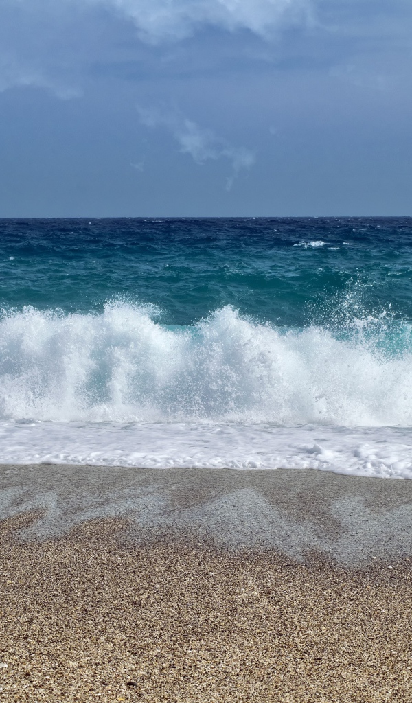 Голубые волны океана на мокром песке 
