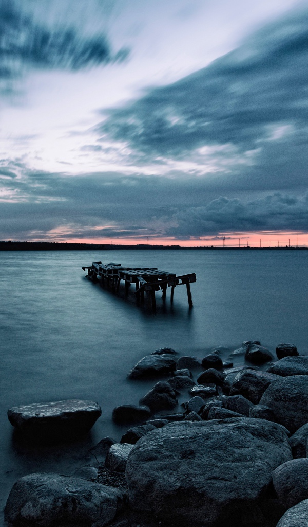 Большие камни на берегу у моря в сумерках 