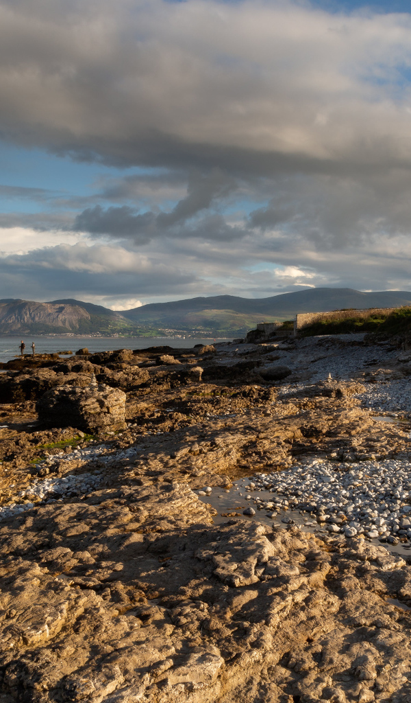 Низкие серые облака над каменным берегом у моря, Великобритания