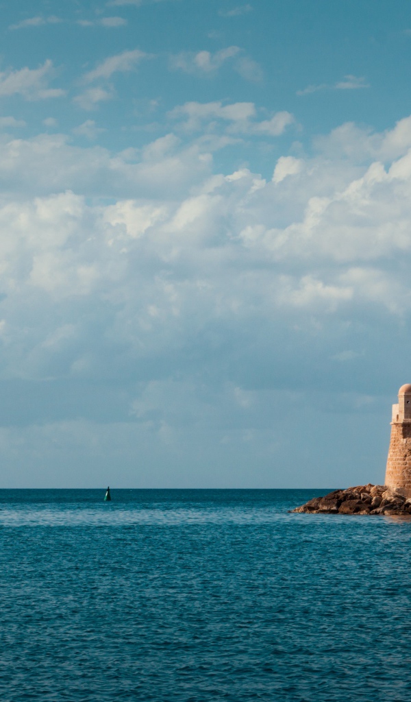 Старый красивый маяк на склоне у моря