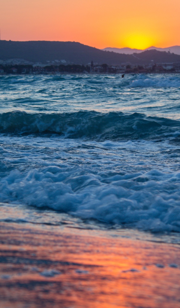 Бушующие волны на берегу моря на закате 