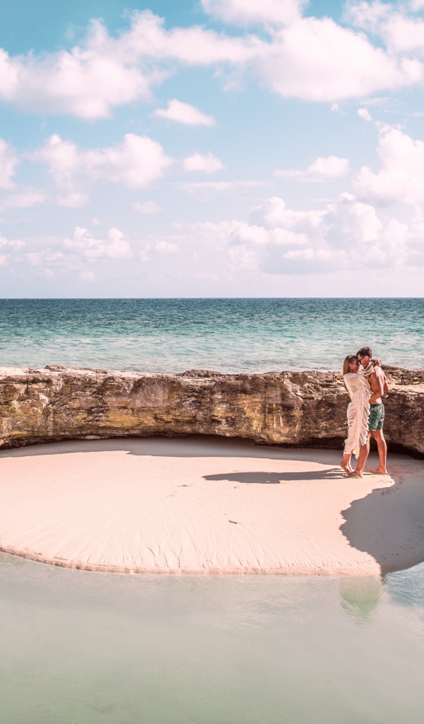 Каменное ограждение на морском пляже летом 