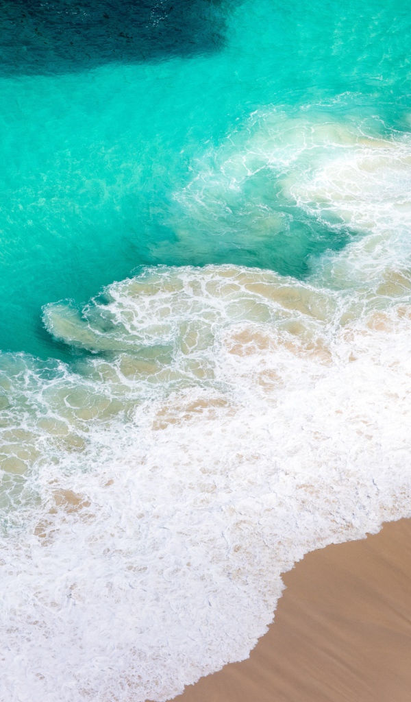 Вид сверху на белые волны прибоя 