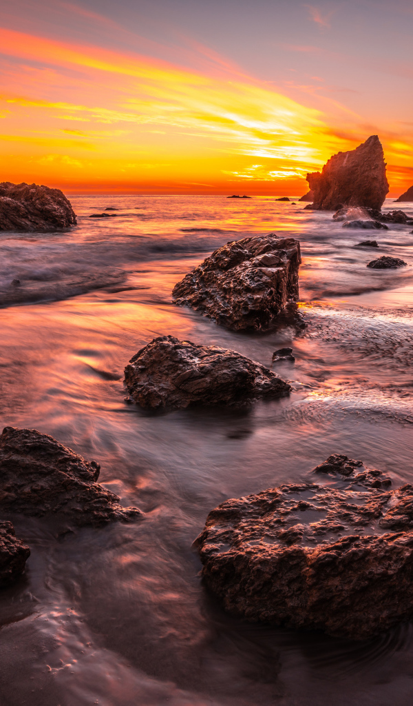 Красивый закат солнца на берегу моря с камнями 