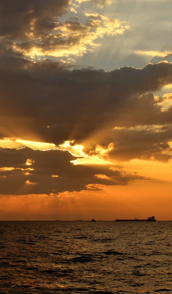 Красивый закат солнца в облаках над морем 