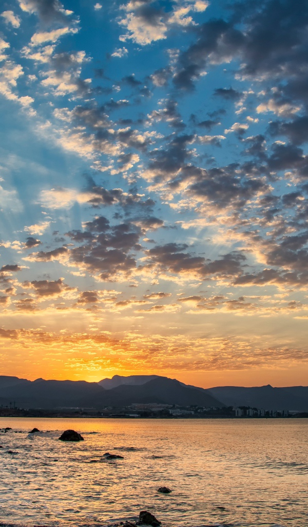 Рассвет солнца за горой у озера 