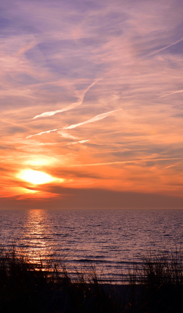Закат солнца над спокойным озером летом