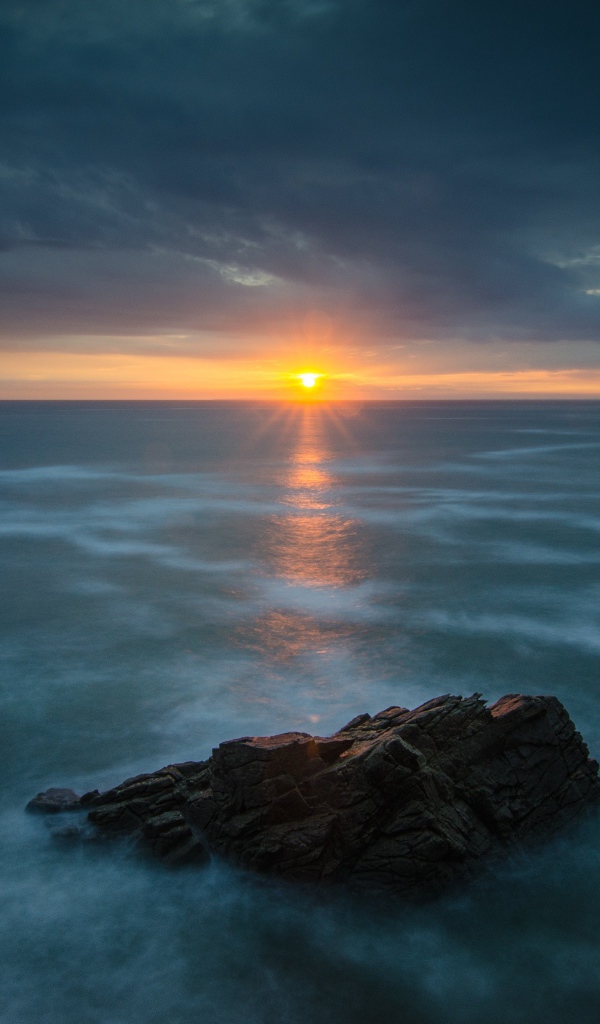 Закат солнца над покрытом льдом озером 