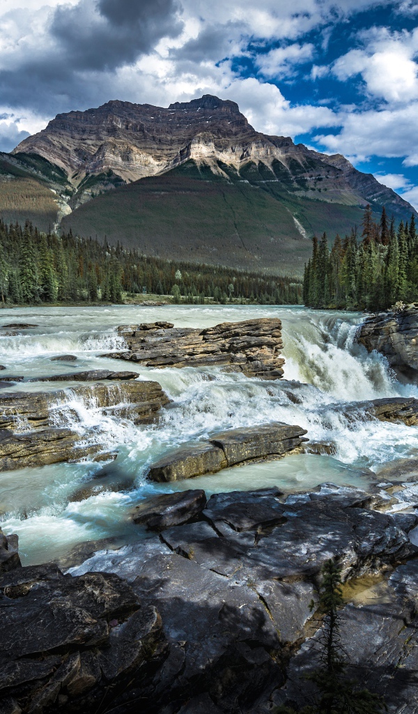 Водопад стекает по камням на фоне горы, Канада
