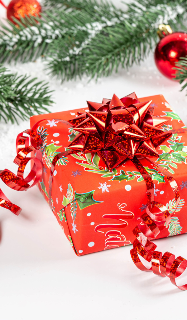 Большой красивый красный подарок с еловой веткой 