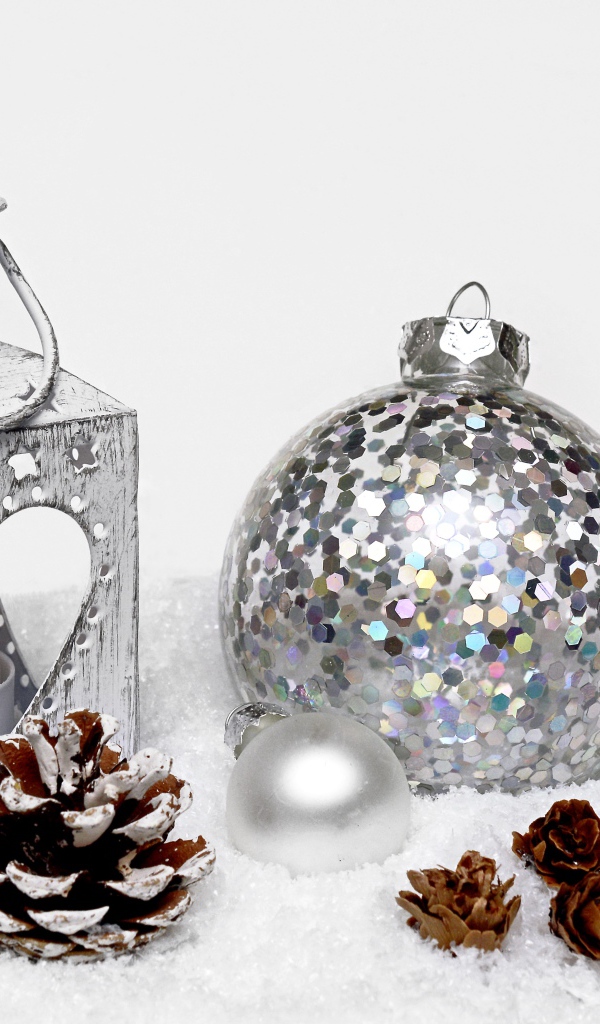 Фонарик и елочный шар с шишками на снегу