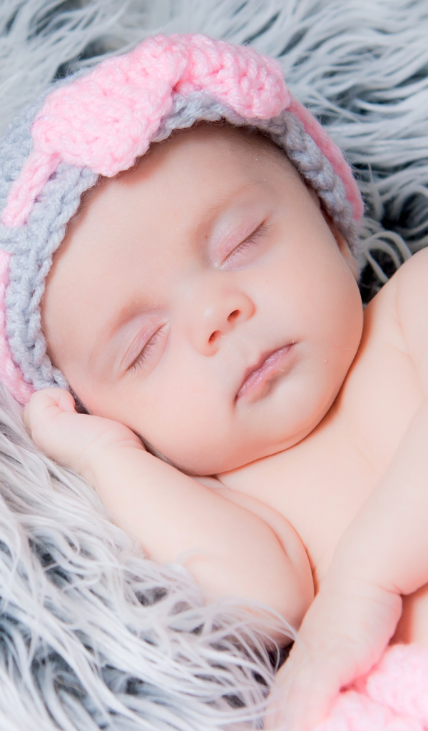 Грудной ребенок спит на меховом одеяле 