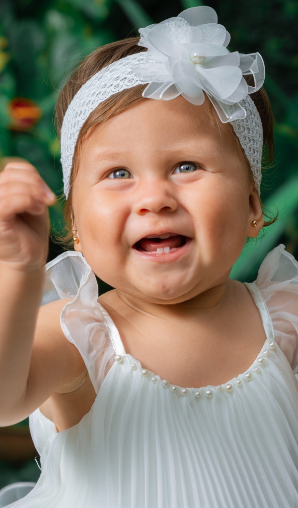 Красивая маленькая девочка в белом платье 