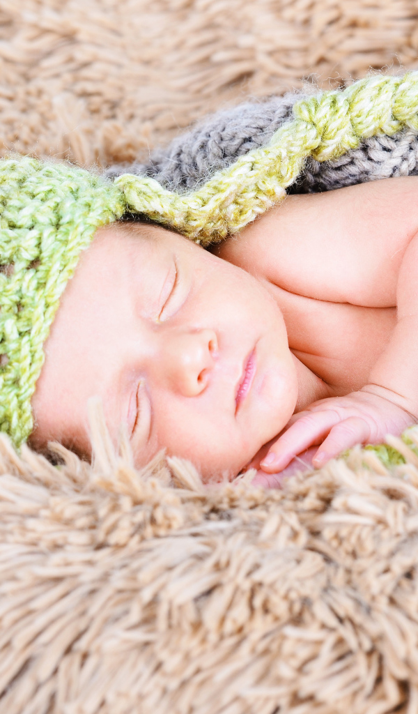 Красивый спящий грудной ребенок в вязаном костюме 