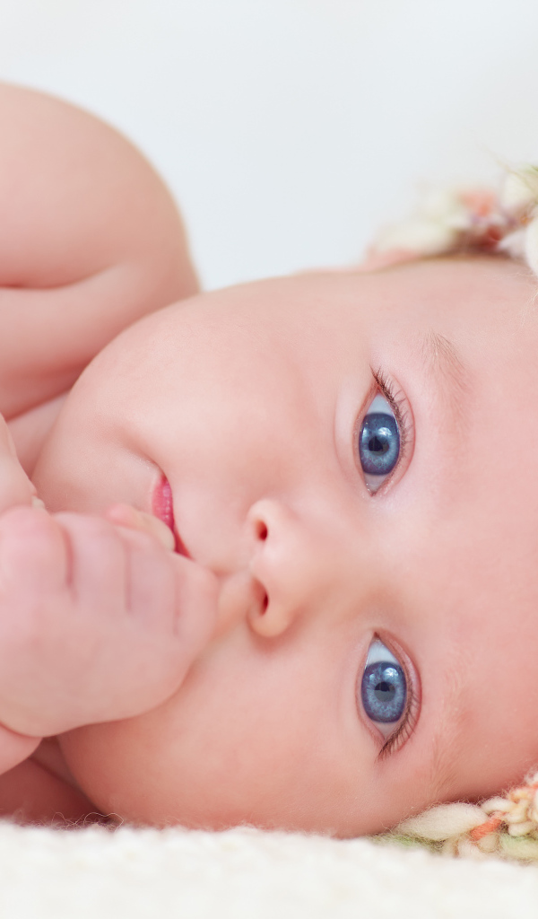 Голубоглазый грудной ребенок в шапке 