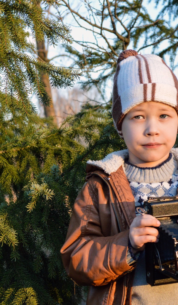Мальчик с фотоаппаратом у ели