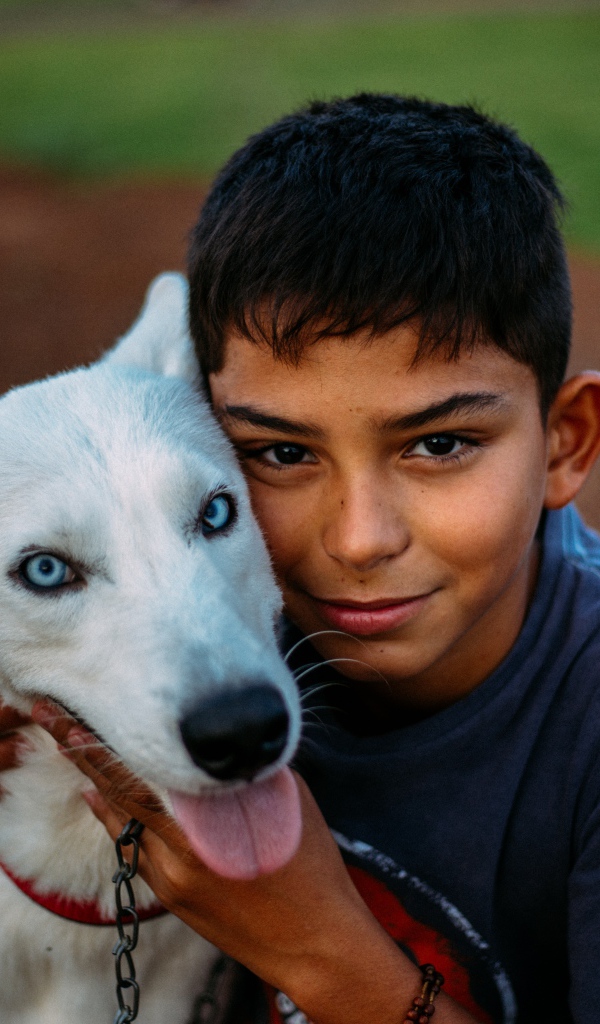 Мальчик с белой собакой с голубыми глазами 