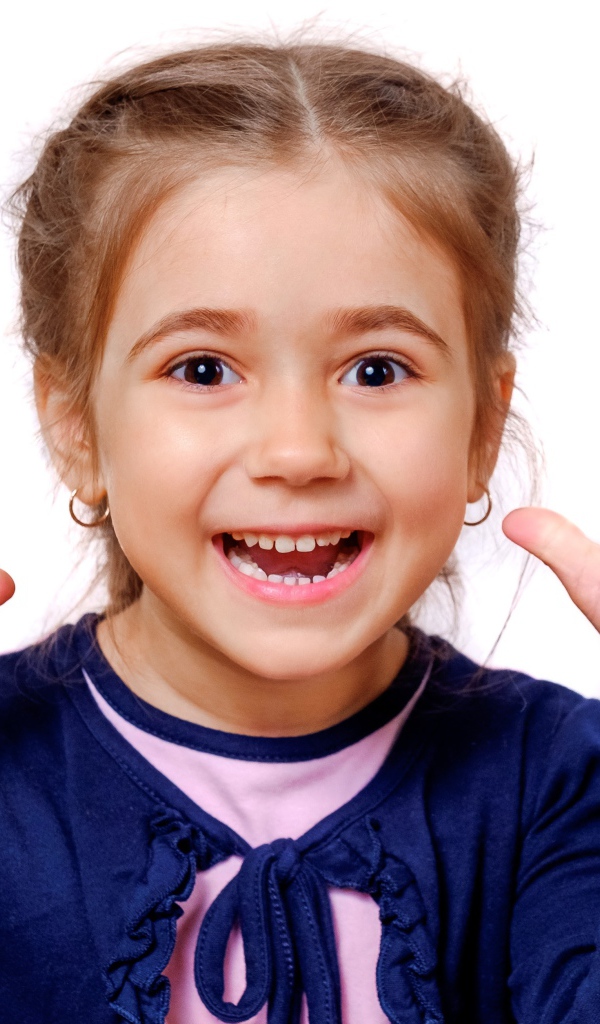 Веселая маленькая девочка с поднятыми руками