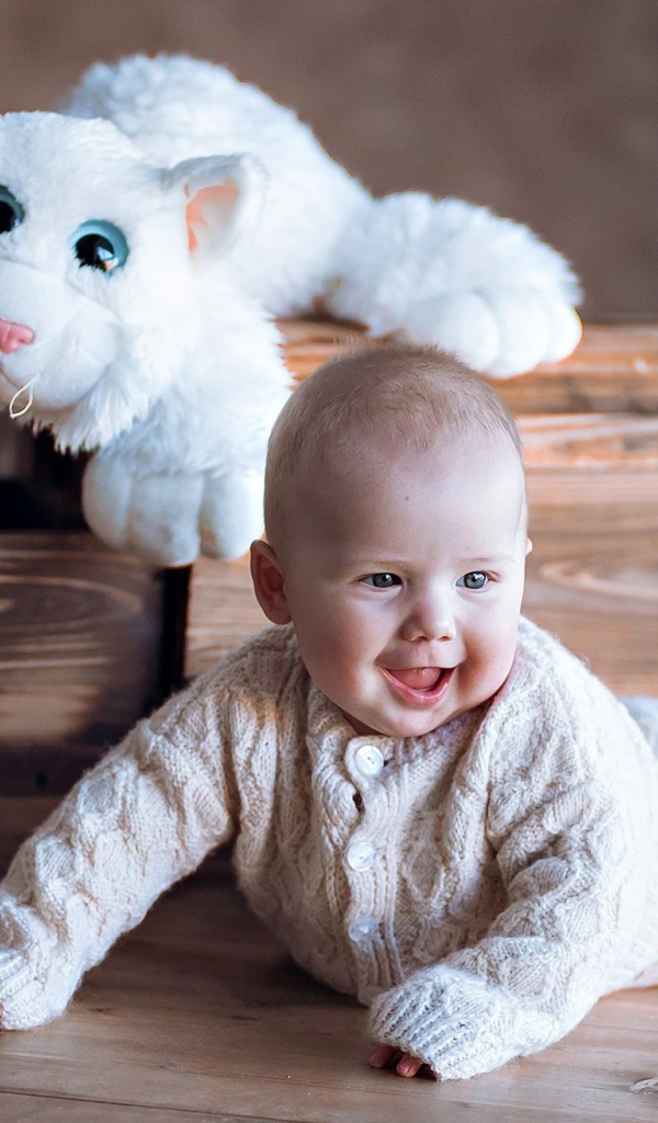 Веселый грудной ребенок с игрушечной машинкой 