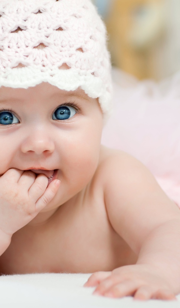 Милая голубоглазая малышка в розовой шапке 