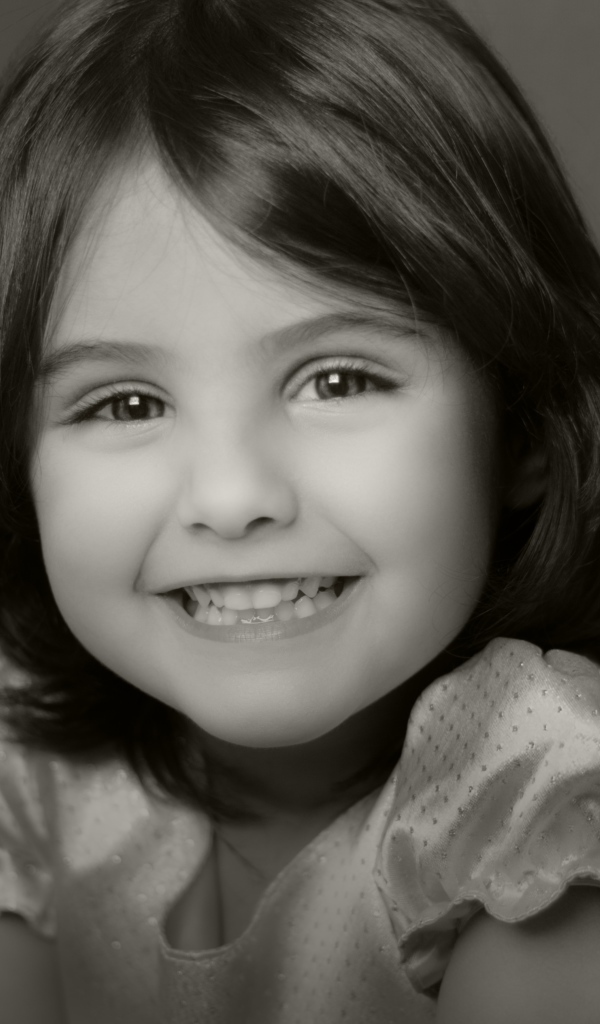 Милая улыбающаяся маленькая девочка черно-белое фото
