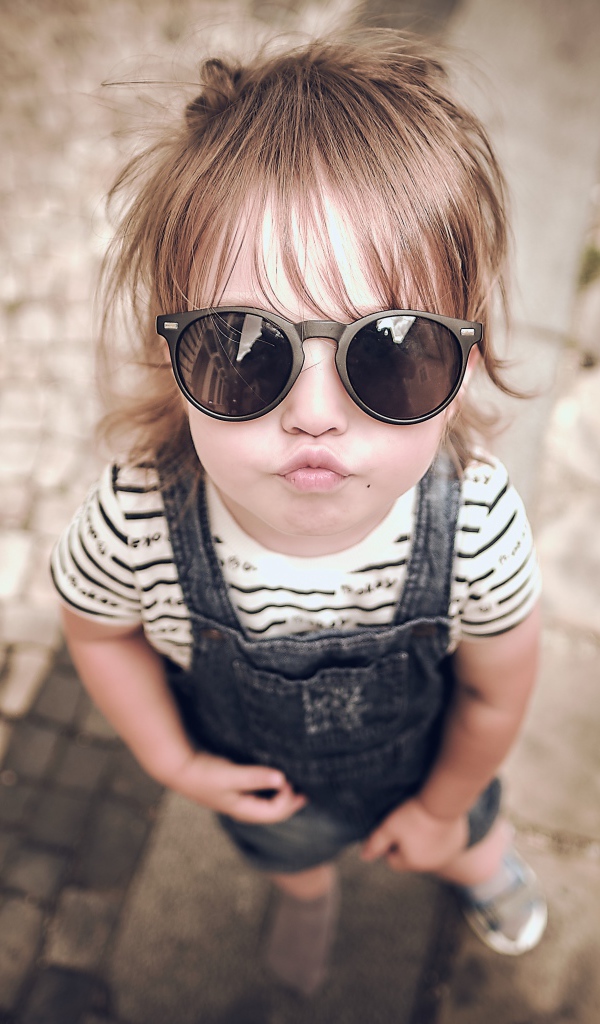 Модная маленькая девочка в черных очках