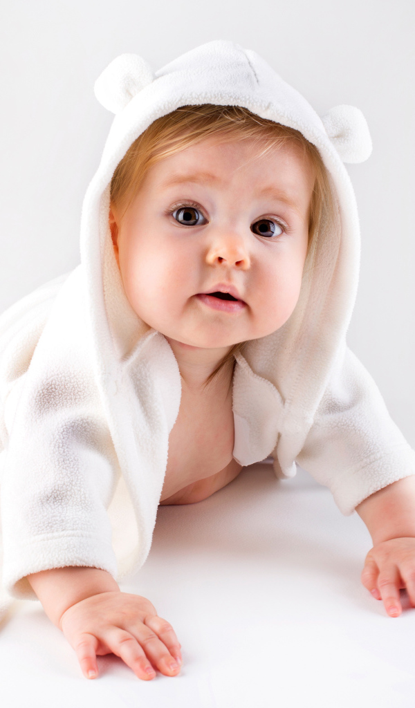 Забавный малыш ползает в белом наряде 