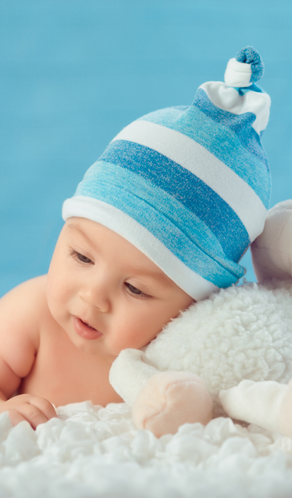 Забавный малыш с игрушкой на голубом фоне