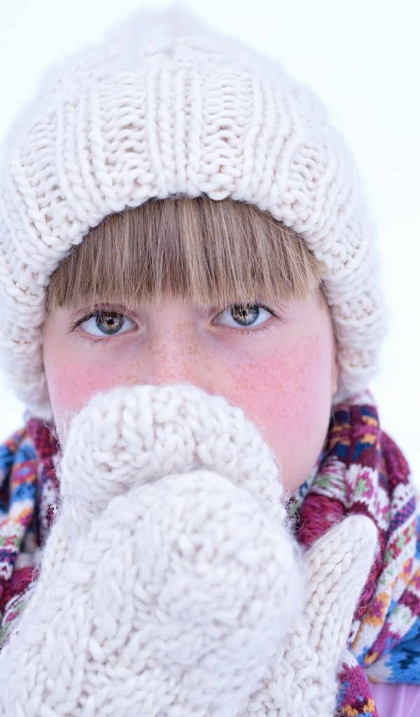 Девочка в рукавицах и белой шапке